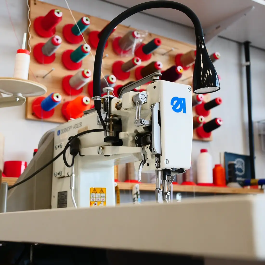 Industrienähmaschine vor der Garnwand in der Werkstatt